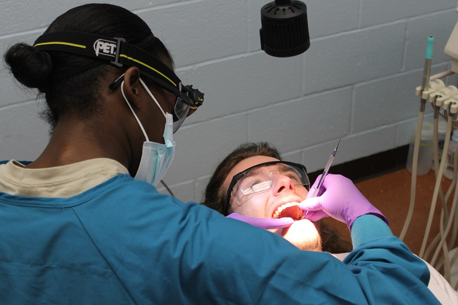 A hygienist cleaning a patient's teeth