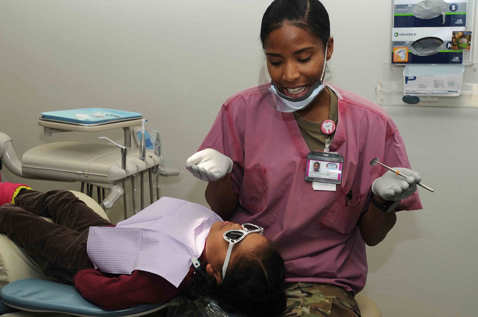 A smiling dental assistant talking with a patient in the chair