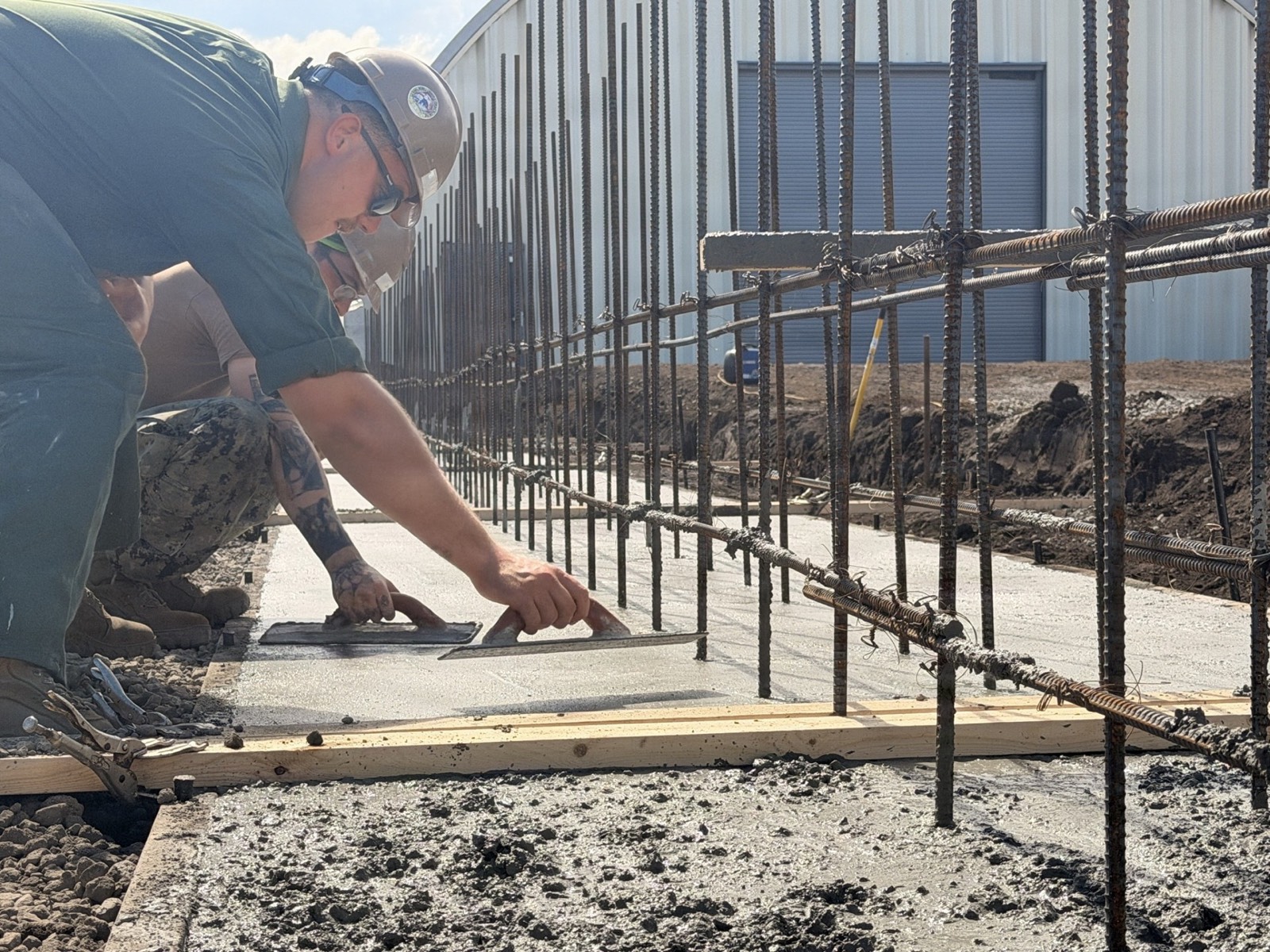 A worker setting steel and forms for concrete