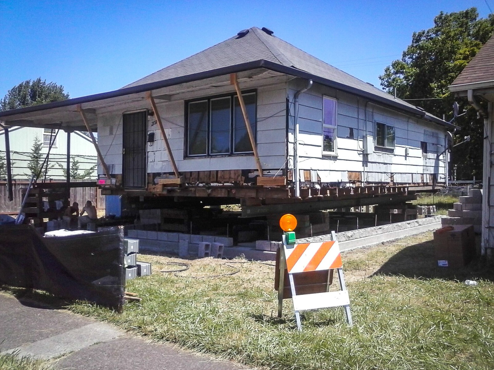 A wooden house raised on cribbing during foundation work