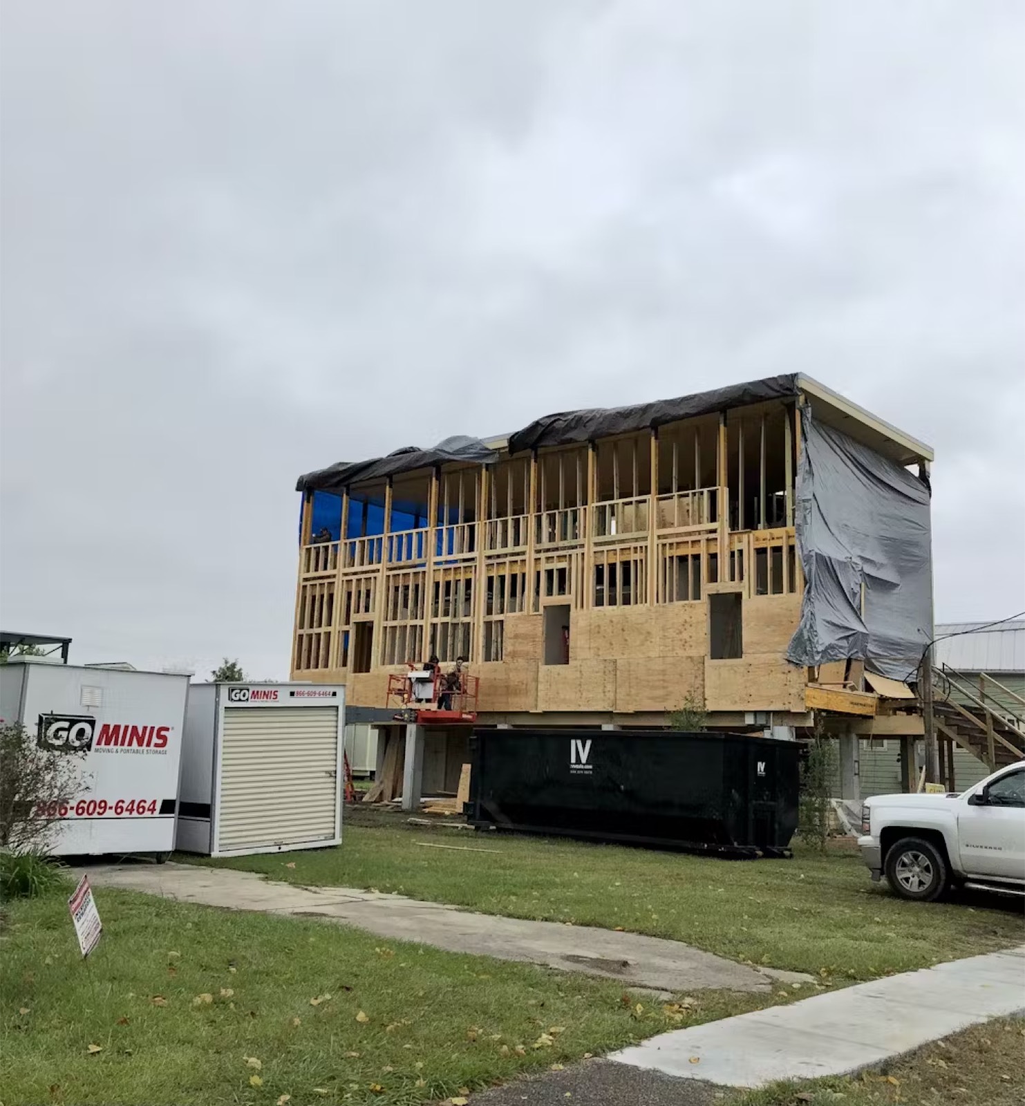 A house lifted on supports above its new foundation