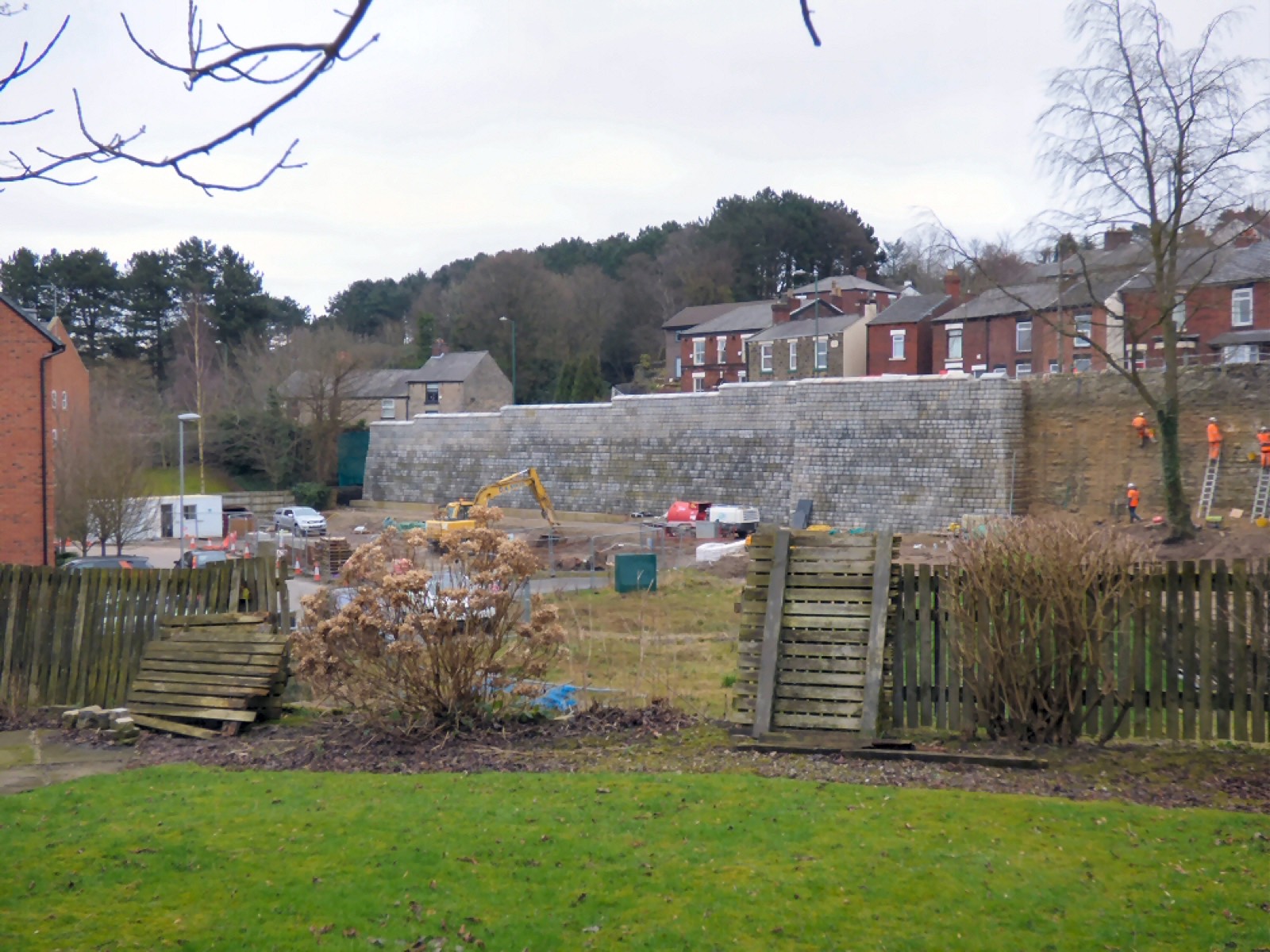 A stone retaining wall holding back a garden slope